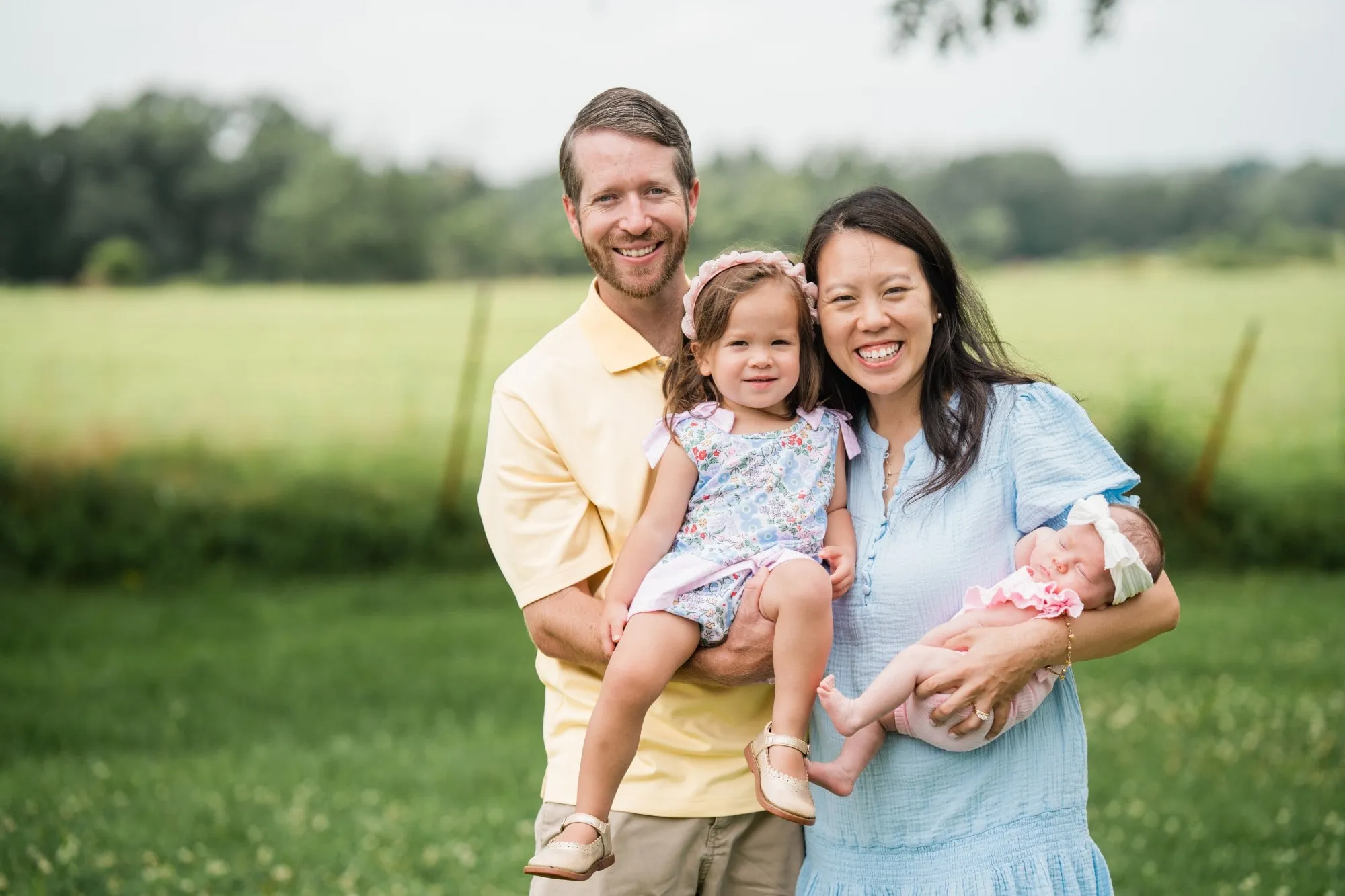 Dr. Nancy Ha with her husband and their two young children, outdoors on a summer afternoon.